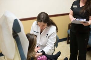 Doctor speaking to child patient in chair