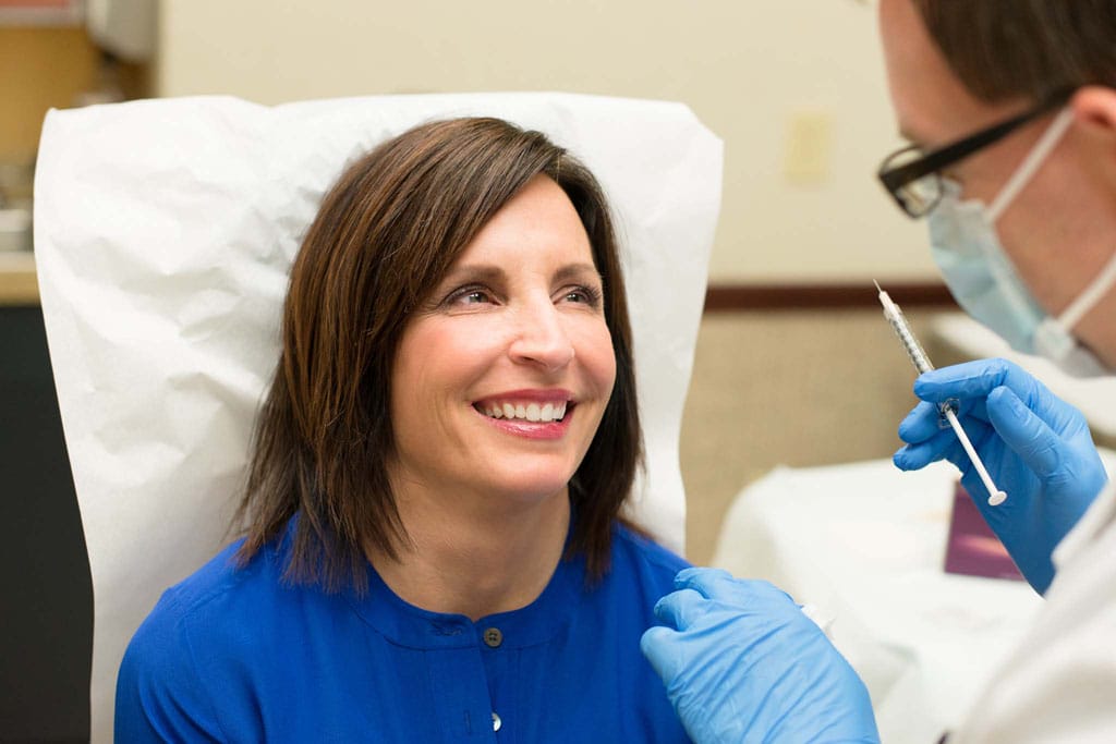 Patient smiing at doctor prior to receiving facial injection