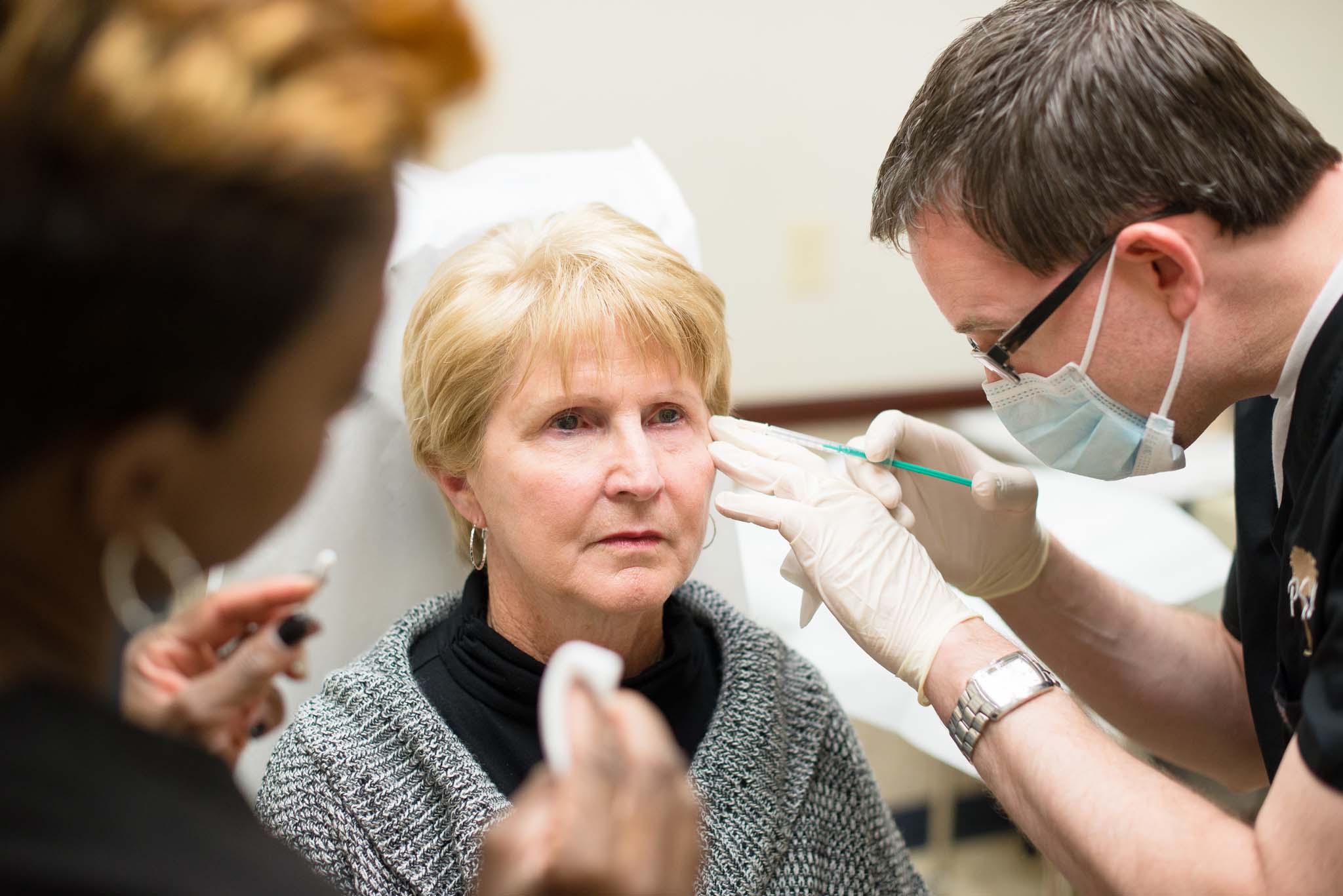 Doctor injecting patient near crows feet wrinkles on face