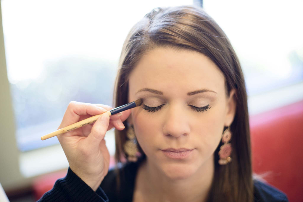 Girl receiving makeup application to eyes